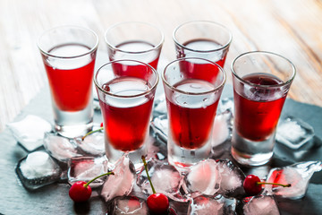 Red alcoholic cocktail with a cherry and ice