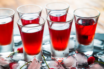 Red alcoholic cocktail with a cherry and ice