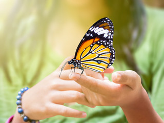 butterfly hanging on girl's finger