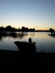 Midnight sun in Finland. Silhouette of motor boat.