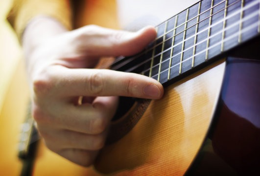 Man hand playing on acoustic guitar