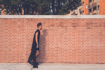 Handsome Asian model posing with a brick wall in background