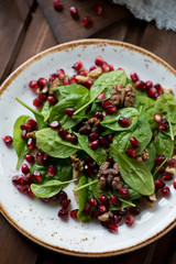 Close-up of spinach, pomegranate seeds and walnuts salad