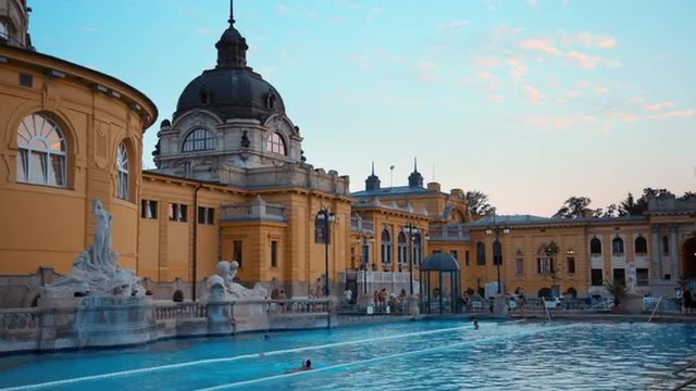 Hungary, Budapest - People swimming in the famous Szechenyi Spa Bath at sunset