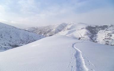 Fototapeta na wymiar Trail in the snow in the mountains