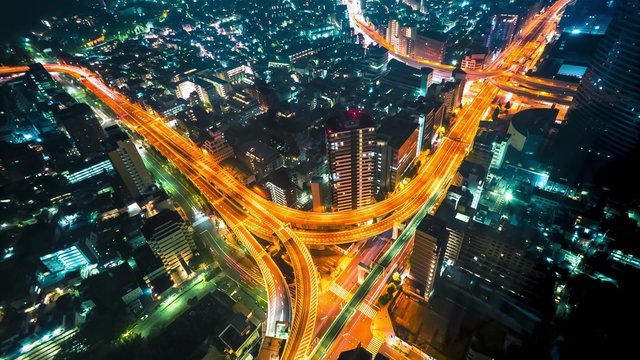 Multi-hour aerial view time-lapse of a massive highway intersection at night in Shinjuku, Tokyo, Japan.