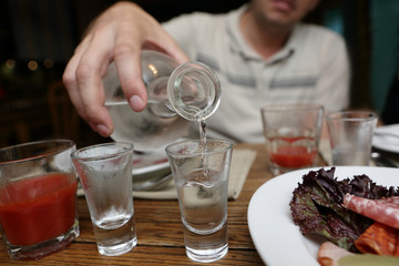 Man pouring vodka from a carafe