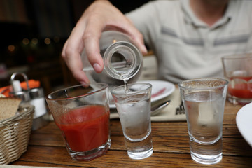 Person pouring vodka from a carafe