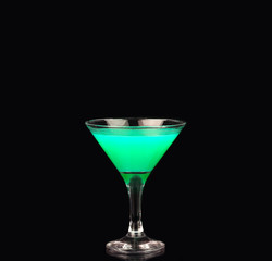 Martini glass with green coctail on black background