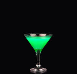 Martini glass with green coctail on black background