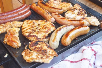 Barbecue on the electric grill.  Summer party, detailed view of grilled chicken and sausage.
