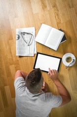 Junger Mann beim Arbeiten am Tablet aus der Vogelperspektive