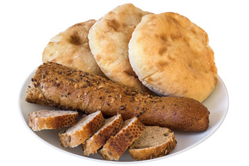 Porcelain Plate with three Pita Bread loafs and Baguette Integral Brown Bread cut in slices,  Isolated on White Background. 