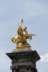 Fototapeta na wymiar Statue au sommet d'un colonne, Pont Alexandre III à Paris