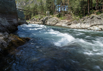 Fototapeta premium During the stormy mountain river among stones