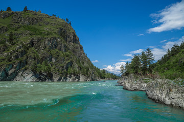 the merger of two mountain rivers in the background peaks