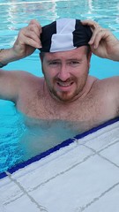 Uomo che si mette la cuffia in piscina