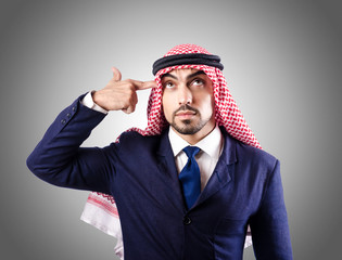 Fototapeta premium Businessman pointing finger gun gesture to head against gray background