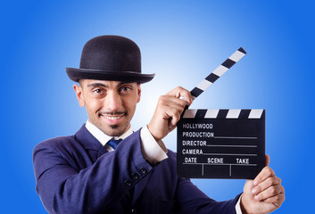 Man with movie clapper against the gradient 