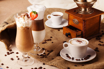 different types of coffee whipped cream strawberries still life with grinder beans