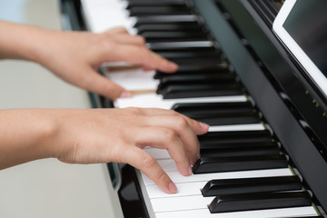Fototapeta na wymiar Close up of woman hands playing piano