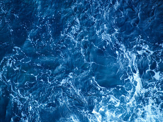 Obraz premium Deep blue sea texture background. Blue ocean waves. Power of the ocean. Sea surface aerial view. Blue aqua sea water. Top view of aqua blue clear sea ocean. 