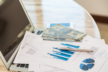 Financial charts on the table with laptop