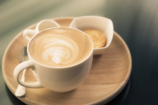 Hot latte art coffee on table ( Filtered image processed vintage