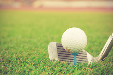 Golf club and ball in grass vintage color