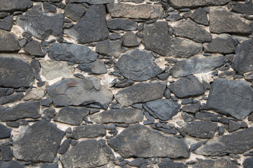 Wall masoned out of weathered dark sandstone