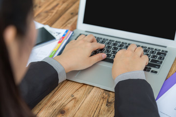 Closeup of business woman hand typing on laptop keyboard