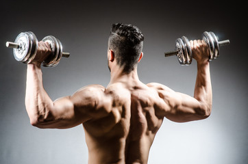 Muscular ripped bodybuilder with dumbbells