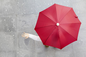 Man holding a red umbrella outdoors