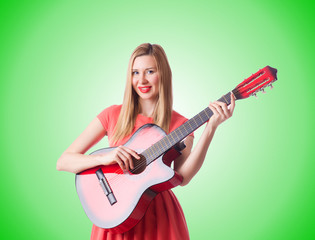 Woman playing guitar against the gradient 