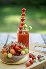 Cherry tomatoes and a glass of tomato juice.