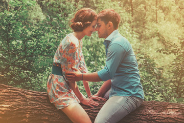Couple in love sitting on tree in summer