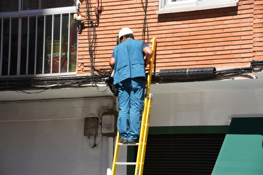 electricista trabajando sobre una escalera