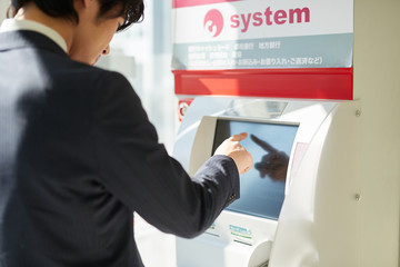 ATMを使うサラリーマン