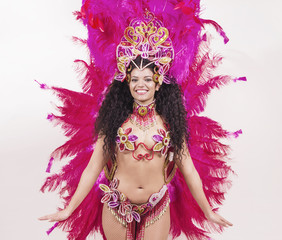 Brazilian samba dancer wearing traditional pink costume and smil