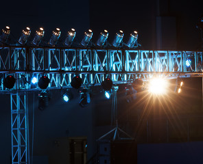 Studio lighting equipment high above an outdoor theatrical performance.