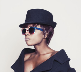 Beautiful african model wearing coat, hat and american sunglasse