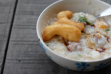 close-up rice gruel and deep-fried doughstick on wood background