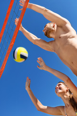 Happy young  couple playing volleyball
