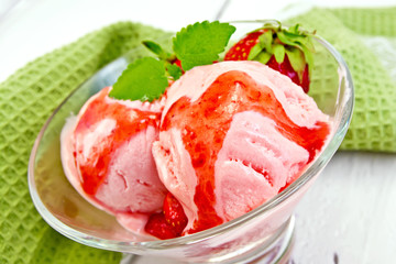 Ice cream strawberry with syrup in glass on board