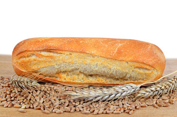 Freshly baked baguette with wheat on the table