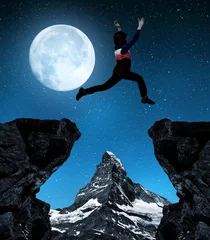 Photo sur Plexiglas Cervin Girl jumping over the gap in night. In the background Matterhorn 