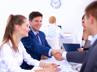 Fototapeta premium Business people shaking hands, finishing up a meeting, in office