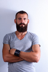 Portrait of handsome bearded man standing, isolated on grey