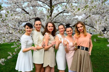 Girls with champagne celebrating in sakura's garden.