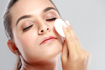 beautiful woman applying some powder using powder puff with clos